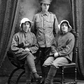 Studio portrait of three young woman in military style clothing.