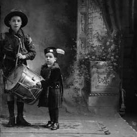 Studio portrait of  two children in Scottish highland costumes.  Family name Moran.