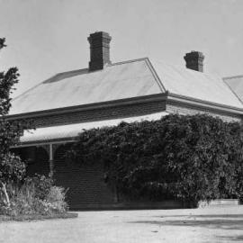 A brick and iron-roofed residence and garden.