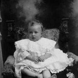 Studio portrait of a baby.  Family name possibly Mills.