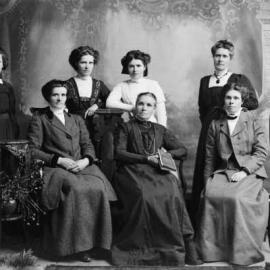 A group of seven women in a studio.