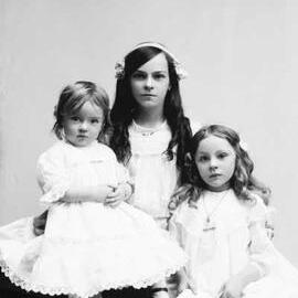 Portrait of three girls wearing white dresses.  Family name Bryne.