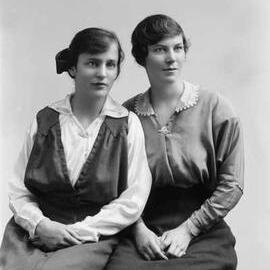 Studio portrait of two women wearing identical brooches.  Family name Tait.