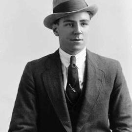 Studio portrait of a young man wearing a trilby hat.  Family name White.