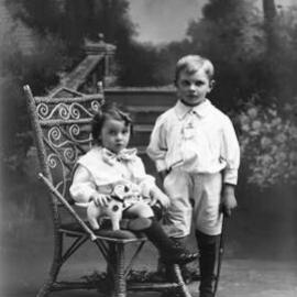 Studio portrait of two children holding toys.   Family name Hanley.