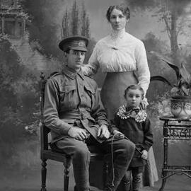 Studio group portrait of a seated man, with a women and boy standing alongside.  Family name Shimmin or Shimmer.