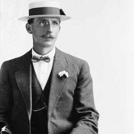 Portrait of a a man in a boater hat and bow tie. Family name Blair.