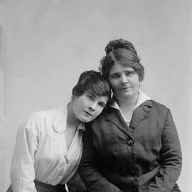 Portrait of two seated women in an affectionate pose.  Family name Dugdell.