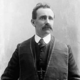 Studio portrait of Mr. Collins wearing an embroidered vest.
