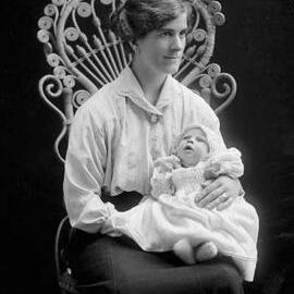 Portrait of a woman holding a young baby.  Family name Donovan.