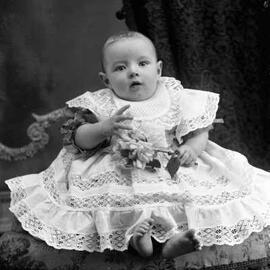 Portrait of a seated baby holding a flower.  Family name possibly  Martin.