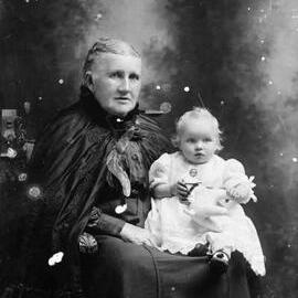 Studio portrait of an elderly woman with a baby.