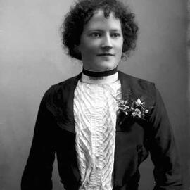 Portrait of  Miss Bell wearing a corsage.