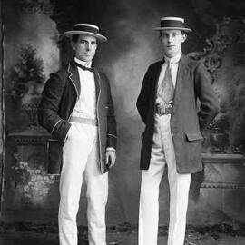 Studio portrait of two young men dressed in jackets and boater hats.  Family name Barr.