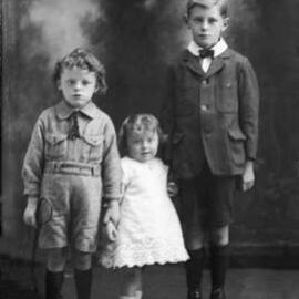 Studio portrait of a group of three children.   Family name Hopper