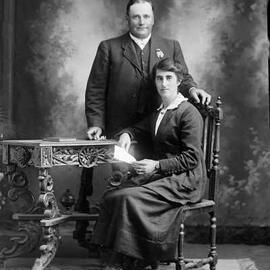 Studio portrait of a standing man and seated woman -  family name Newton.