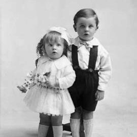 Studio portrait of a young girl and boy.   Family name possibly Rine.