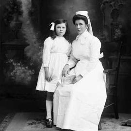 Studio portrait of Nurse Moore with an un-named girl.
