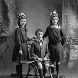 Studio portrait of a group of three adolescent children.   Family name Harrigan.