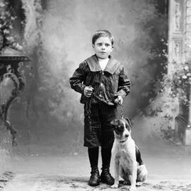Studio portrait of a boy with a dog.