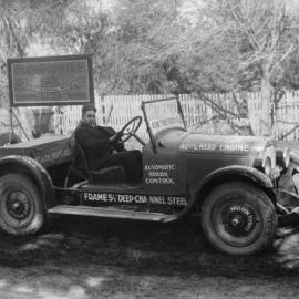 A man sitting at the wheel of an Oldsmobile demonstration car.
