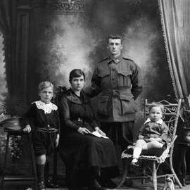 Studio group portrait of a woman, man and two young boys.  Family name Syme.