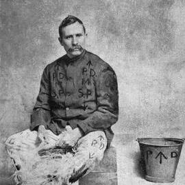 Tom Mann in a prison uniform picking oakum.