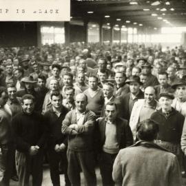 A large group of workers at a meeting in the Engagement Centre for waterside labour on the Melbourne waterfront.