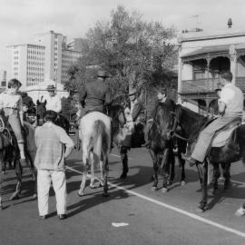 A group of people mounted on meatworker's horses at the start of a May Day March in Melbourne.
