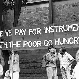"While we pay for instruments of death the poor go hungry" banner outside U.S. consulate during Persian Gulf war protest, 14 January 1991.