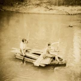 Lorri and Malcolm Fraser paddling a makeshift raft on the river at Nyang, New South Wales.