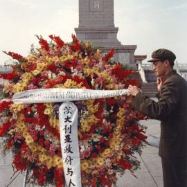 A Chinese soldier attaching a banner to an Australian wreath in front of the Monument to the People's Heroes in Tiananmen Square, Beijing, China.