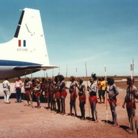 A group of welcoming Aboriginal Australians standing alongside a Royal Australian Air Force aircraft in the Northern Territory.