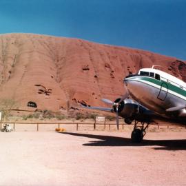 A Douglas DC3 aircraft at the base of Uluru (Ayres Rock).