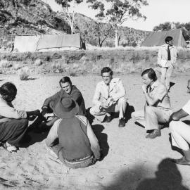 Malcolm Fraser speaking with two Aboriginal men while sitting in the dry bed of the Todd River, Alice Springs.