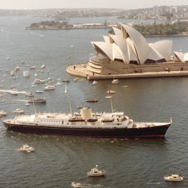 The Royal Yacht Britannia passing the Sydney Opera House near Circular Quay in Sydney Harbour.