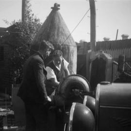 Two men studying unknown machinery