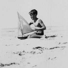 Malcolm Fraser as a boy with a model yacht at an unknown beach.