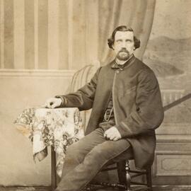 Studio portrait of an unidentified man wearing a frock coat.
