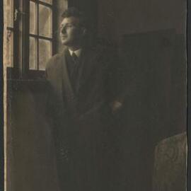 Napier Waller standing, gazing out window