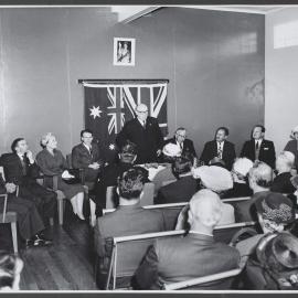 Man in suit talking to group of adults, Winlaton