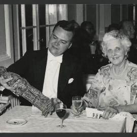 Thurston Dart holding the Grand Prix du Disque award seated next to an elderly Louise Hanson-Dyer