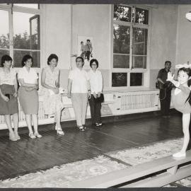 [Tamie Fraser and others watching a gymnastics demonstration]