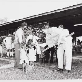 [Malcolm Fraser shaking hands with an unidentified Aboriginal Australian girl during a visit to the Northern Territory]