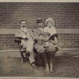 [Three men and one young boy seated together]