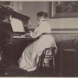 [Alice seated at piano