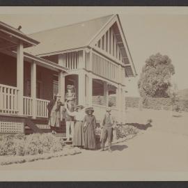 [Group photo, men and women in front of house]