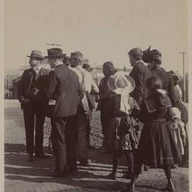 [Crowd of men, women and children]