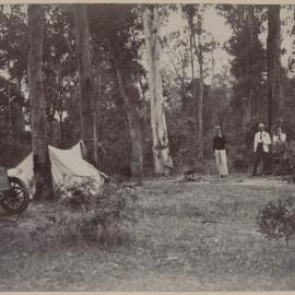 [Two men and a woman at a campsite]