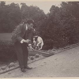 [Man with dog jumping over stick, Harleston]